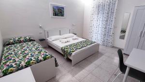 a bedroom with two beds and a table and a desk at Marricrio House in Catania