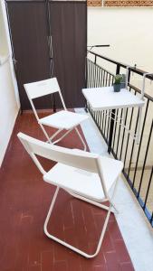 2 sillas blancas en la parte superior de un balcón en Marricrio House, en Catania