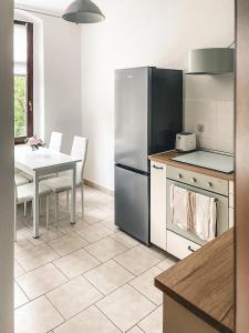 a kitchen with a table and a stainless steel refrigerator at Zentrum, 2R, Balkon, WiFi, 4P, modern, ruhig in Chemnitz