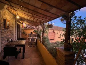 an outdoor patio with a wooden table and chairs at Les Vinyes Alojamiento Rural Boutique & SPA in Vilardida