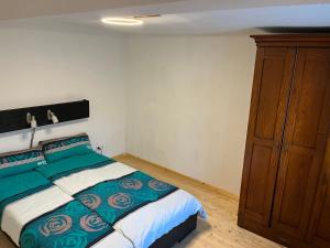 1 dormitorio con 1 cama y armario de madera en Landhaus inklusive Parkplatz, en Schotten