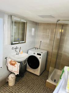 La salle de bains est pourvue d'un lavabo et d'un lave-linge. dans l'établissement Landhaus inklusive Parkplatz, à Schotten