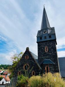 a church with a tower with a clock on it at Landhaus inklusive Parkplatz in Schotten
