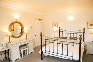 a bedroom with a bed with a fireplace and a mirror at Milebrook House in Knighton