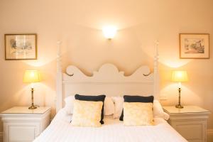 a bedroom with a white bed with two lamps at Milebrook House in Knighton