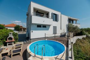 una casa con piscina delante de una casa en MALO Ferienvilla Privlaka, Pool, Boje, WI-FI, Wallbox, en Privlaka