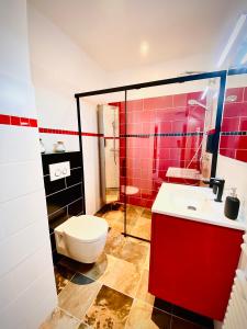 ヴィルヌーヴ・ルベにあるBaie-Des-Anges Studio Front de Merの赤いバスルーム(トイレ、洗面台付)