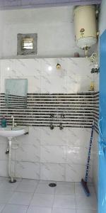 Baño blanco con lavabo y espejo en Zigzag Homestay en Agra