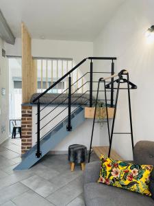 a spiral staircase in a living room with a couch at BE MY APPARTS, Studio de charme "LE CARILLON", DOUAI, Coeur de ville in Douai