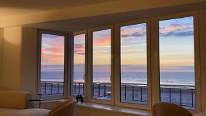 a room with windows looking out at the ocean at Zeedijk Oostduinkerke frontaal zeezicht - volledig gerenoveerd 2022! in Oostduinkerke