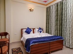 a bedroom with a bed with blue pillows at Divine Hills Mashobra in Shimla