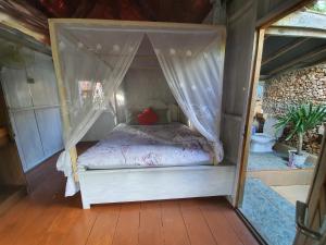 a small bed with a canopy in a room at Scuba Republic Beach Bungalows in Bira