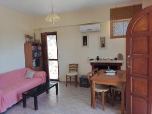 sala de estar con sofá rosa y mesa en Stone House en Triopetra