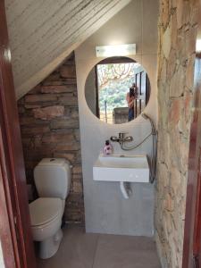 a bathroom with a toilet and a sink and a mirror at Stone House in Triopetra