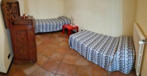 Habitación con 2 camas y mesa roja. en Antica Postumia en Pieve San Giacomo