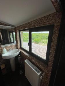 un bagno con ampia finestra e lavandino di Motel Orion 