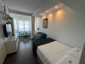 a bedroom with a bed and a tv and a couch at Céntrico apartamento en el Riscal in Alicante