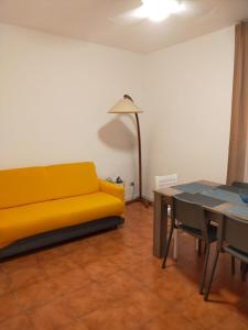 ein Wohnzimmer mit einem gelben Sofa und einem Tisch in der Unterkunft Locazione turistica di Via Ottaviano a Roma in Rom