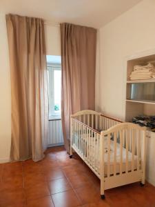ein Babyzimmer mit einem Kinderbett und einem Fenster in der Unterkunft Locazione turistica di Via Ottaviano a Roma in Rom