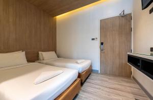 曼谷的住宿－水門皮瑞德酒店，小房间设有两张床和电视