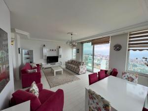 a living room with red chairs and a white table at TRABZON PANORAMA APART in Trabzon