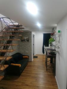 uma sala de estar com um sofá e uma escada em espiral em Apartmani Kiko em Porec