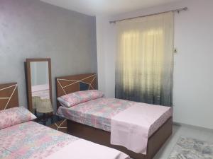 1 dormitorio con 2 camas y espejo en Furnished Apt At Mohandeseen families only, en El Cairo