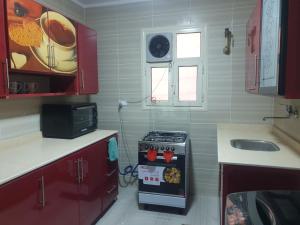 una pequeña cocina con fogones y fregadero en Furnished Apt At Mohandeseen families only, en El Cairo