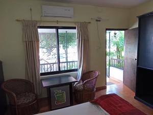 a living room with a large window and chairs at Pokhara Cottage in Pokhara