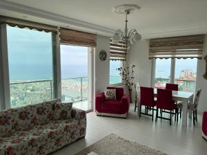 a living room with a couch and a table and chairs at TRABZON PANORAMA APART in Trabzon
