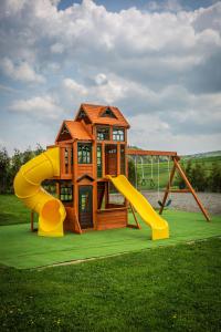 a play house with a slide and a playground at Domki w Bieszczadach - Apartamenty in Hoczew
