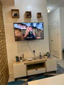 a living room with a tv on the wall at Romantic Studio Unit, Matina Enclaves Residences in Davao City +2 photos