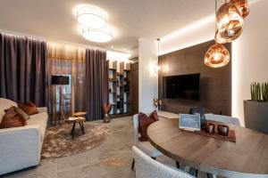 a living room with a table and a couch and a tv at Sibenbras Natural Aparthotel in Limone sul Garda