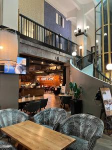 a restaurant with tables and chairs and a staircase at Upea loftsuite, järvinäkymä, wifi, sauna & spa in Tampere