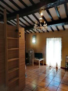 a living room with a chandelier and a room with a table at Casa di Olly - Loft incantevole con camino in Ponticelli
