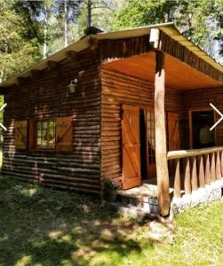 Cabaña de madera con porche y puerta en Ma Cabane Au Bord Du Lac en Neuvic