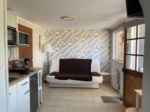 a living room with a couch in a kitchen at Petite maison, quartier calme. in Bourges