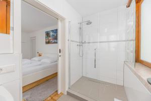 biała łazienka z prysznicem i łóżkiem w obiekcie Hotel am Schlossplatz w mieście Hechingen