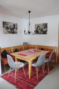 a dining room table with four chairs and a chandelier at Ferienhaus Pfeiffer in Schwangau