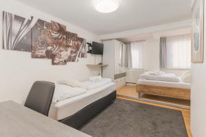 Sala de estar con 2 camas y mesa en Hotel am Schlossplatz en Hechingen