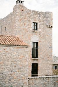 an old stone building with windows and a roof at Castello di Haria in Kaloú