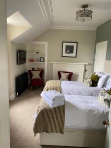 a bedroom with two beds and a chair in it at Beinn Mhor Lodge in Inverness