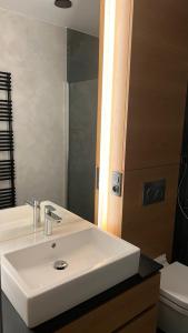bagno con lavandino bianco e specchio di Kamel club restaurace a penzion a Olomouc