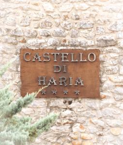 a sign on the side of a stone wall at Castello di Haria in Kaloú