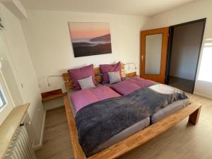 1 dormitorio con 1 cama grande con sábanas moradas en Ferienwohnung Elfengast, FassSauna, Harzurlaub in bester Lage en Bad Harzburg