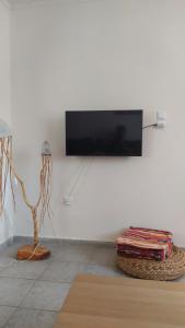 a living room with a tv on a white wall at Thalia's place in Áno Kateliós