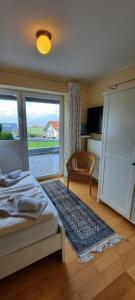 a bedroom with a bed and a large window at Panoramablick in Rettenberg