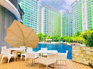 a patio with a table and chairs and a pool at AZURE URBAN RESORT A3 near airport mall with Balcony wavepool in Manila