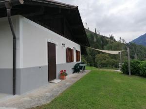 a white building with a table and a grass yard at "La Casina" Relax e Natura a Canal San Bovo in Canale San Bovo