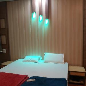 a bedroom with a bed with blue lights on it at Hotel Vilas, Prayagraj in Allahābād